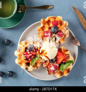 Waffles with fresh fruit, chocolate, caramel, and ice-cream, overhead square shot Stock Photo