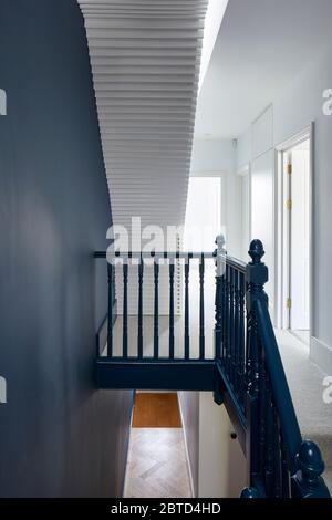 Landing area with staircase with ribbed wooden slat design. Long House, London, United Kingdom. Architect: R2 Studio , 2018. Stock Photo