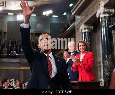 President Barack Obama waves to the First Lady and guests seated in the gallery of the House Chamber at the U.S. Capitol in Washington, D.C., Sept. 9, 2009. IN the background are Vice President Joe Biden and Speaker of the House Nancy Pelosi. Stock Photo