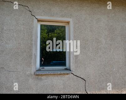 Building damage in a wall at the window cracks Stock Photo