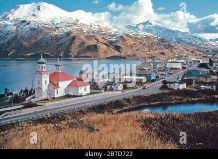 The red and green roof of a Russian-Orthodox-style church brings a spot of color to the mountainous winter landscape in this Unalaska scene. Stock Photo