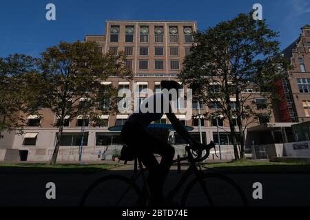 A woman cycles past Royal Dutch Shell Plc headquarters building on May 21, 2020 in The Hague, Netherlands. Credit: Yuriko Nakao/AFLO/Alamy Live News Stock Photo