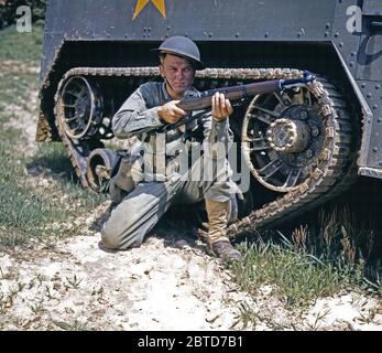 A young soldier of the armored forces holds and sights his Garand rifle like an old timer, Fort Knox, Ky.  - June 1942 Stock Photo