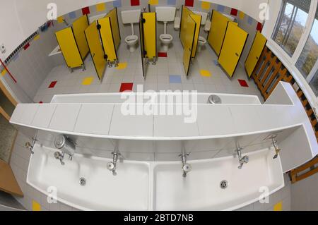 Interior of nursery bathroom with small yellow doors and white ceramic sink photographed by fisheye lens Stock Photo