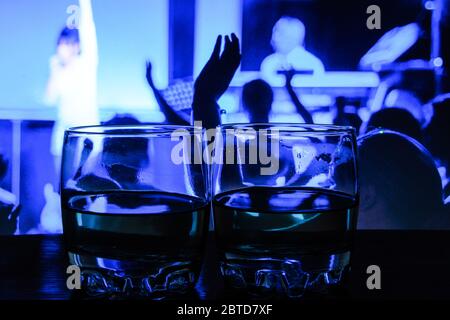 colored lighting of glasses in the night club bar, Two glasses of vodka closeup Stock Photo