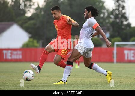 English-born Chinese football player Nico Yennaris, known in China as Li Ke, of China national football team, left, struggles for the ball against Brazilian football player Givanildo Vieira de Sousa, known as Hulk, of Shanghai SIPG F.C., right, during a warmup match, Shanghai, China, 21 May 2020. China national football team slashes Shanghai SIPG football club with a 4-1 during a warmup match held in Shanghai, China. Stock Photo