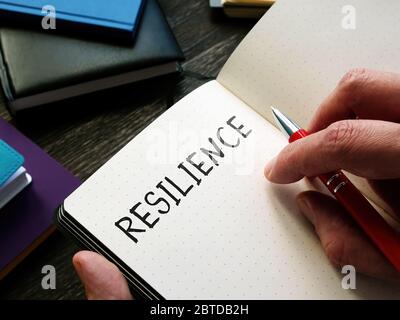 Resilience handwritten on the notepad page. Stock Photo