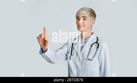 Doctor hand touching empty virtual screen. Friendly woman and modern technology Stock Photo