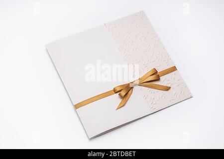 Greeting card with gold ribbon isolated on white background. Stock Photo