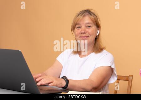 Mature attractive business lady enjoying her job, working from home with laptop Stock Photo