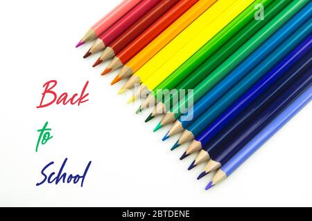 Bright beautiful crayons. Colorful pencils isolated on white background and text Back to School. Stock Photo