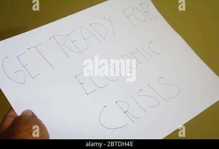 hands holding a paper, get ready for economic crisis text. Stock Photo