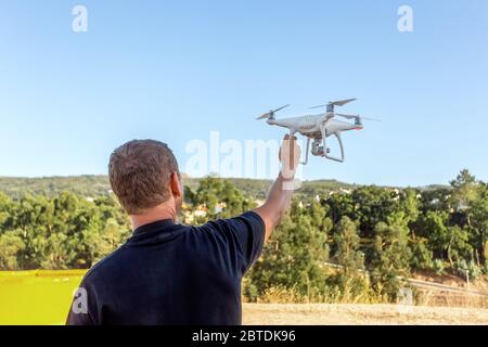 Man, an engineer pilot, a drone, prepares air device for take-off, for testing and filming a vileo and photograph. By controlling the remote Stock Photo