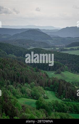 light rays on forest infront green cornfiled and thunderstorm clouds grteen valley Stock Photo