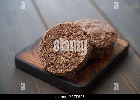 Keto bread. Tasty almond flour ketogenic buns, homemade with crust and sesame seeds on wooden board Stock Photo