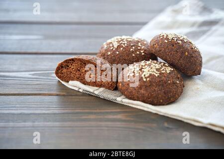 Keto bread. Tasty almond flour ketogenic buns, homemade with crust and sesame seeds on wooden board Stock Photo