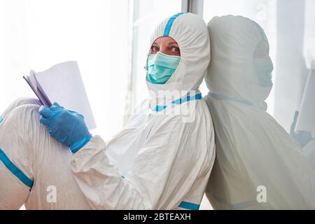 Health Department employee in protective clothing holds checklist for contact tracking during Covid-19 pandemic Stock Photo