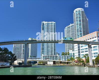 x›MIAMI, USA - MARCH 19, 2017 : Metromover train goes through the bridge on Miami river in Downtown. Metromover is a free automatic transport system i Stock Photo