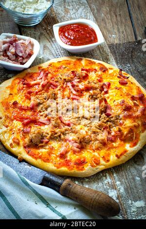 Handmade chicken and bacon pizza on wooden table Stock Photo