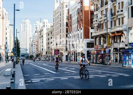 Madrid, Spain - May, 23, 2020: Cyclists riding on an empty Gran Via Avenue during Covid-19 pandemic lockdown Stock Photo