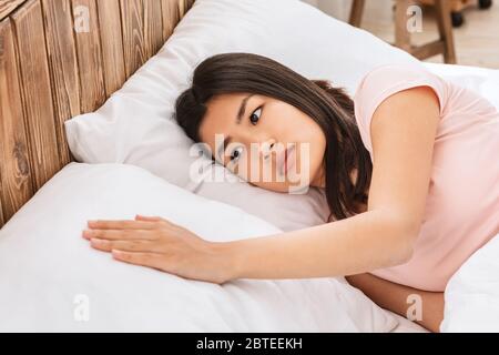 Sad Girl Touching Pillow Suffering From Loneliness Lying In Bed Stock Photo