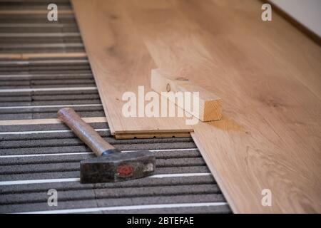 Laying and installing solid parquet above underfloor heating Stock Photo