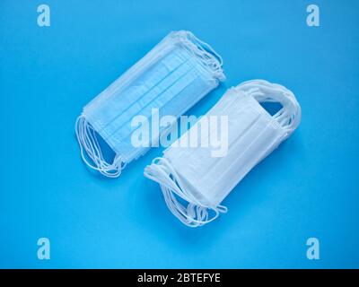 Prevent coronavirus. Medical protective masks isolated on blue background. Disposable surgical face mask cover mouth and nose. Healthcare medical coro Stock Photo