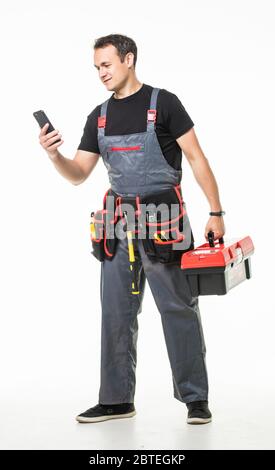 Male worker or builder with smartphone and working tools on belt and box over grey background Stock Photo