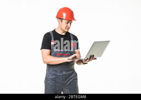 Full body view of a construction contractor working on his laptop isolated on white background Stock Photo