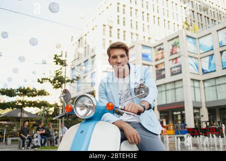 Fashionable couple posing on the street, siting on scooter , wearing  stylish casual clothes. Stock Photo | Adobe Stock
