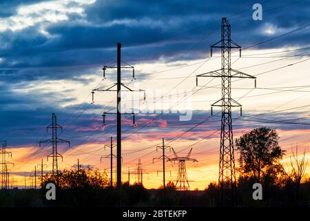Electric power lines against vivid sunset sky. Industrial landscape Stock Photo