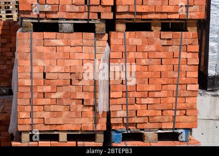 Bricks on pallets. Storage of bricks at the construction site. Stock Photo