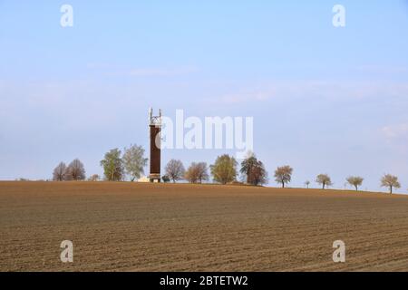 Wooden Telecommunication tower with transmitters. Cellular base station with transmitter antennas on telecommunication tower on against a blue sky wit Stock Photo