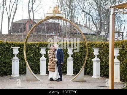 newlywed couple on a walk in the park on early spring snowy day Stock Photo
