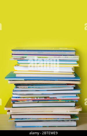 Many children's books are stacked on top of each other. Green background. Stock Photo