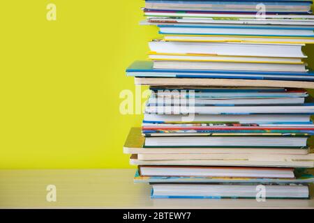 Many children's books are stacked on top of each other. Green background. Stock Photo