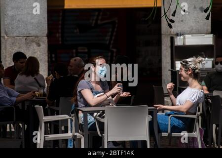 Madrid, Spain. 25th May, 2020. A customer wearing protective face mask in an outdoor terrace table of a cafe in Plaza Mayor using hand sanitizer. Madrid has entered the so-called Phase One transition of the coronavirus lockdown, allowing many shops to reopen as well as restaurants to serve customers outdoors. Credit: Marcos del Mazo/Alamy Live News Stock Photo