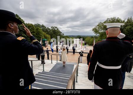 President Donald Trump, center, salutes after placing a wreath at the Tomb of the Unknown Soldier in Arlington National Cemetery, in honor of Memorial Day, Monday, May 25, 2020, in Arlington, Va. First lady Melania Trump looks on, center foreground. (AP Photo/Alex Brandon) Stock Photo