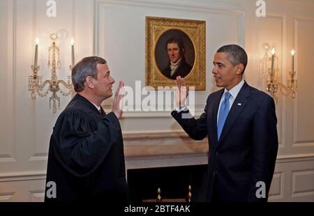 President Barack Obama is given the Oath of Office for a second time by Chief Justice John G. Roberts, Jr.  in the Map Room of the White House 1/21/09. Stock Photo