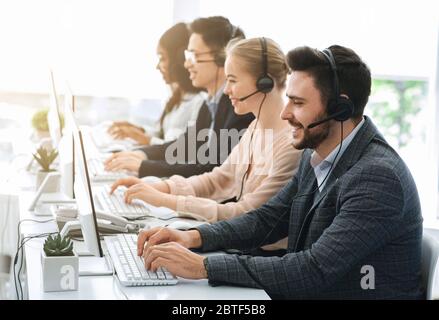 Telemarketing or hotline operators working with computers at light office Stock Photo