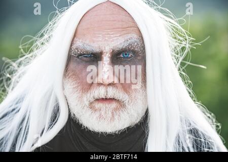 Devil man with angry face with Halloween make up. Devil vampire man. Happy Halloween - handsome Demon isolated on dark background Stock Photo