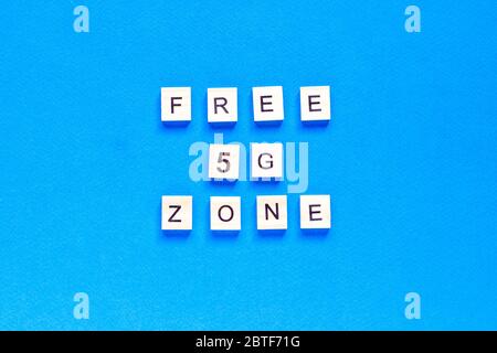 free 5 g zone. 5 G. Five G's, written in wooden letters on a blue background. Flat layout. Wireless network. New technology. top view. Stock Photo