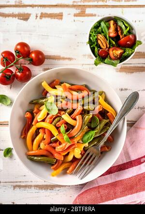 Close up of delicious colorful penne pasta on white table form above