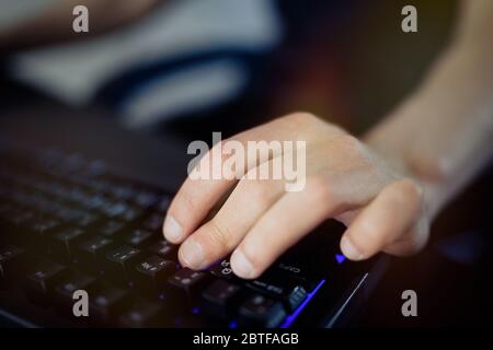 Hand of gamer playing in the video game using keyboard Stock Photo