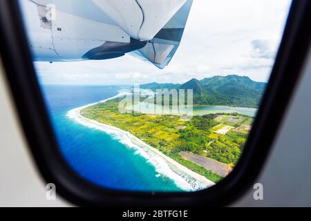 Wing of an airplane flying above the ocean, Huahine, French Polynesia. With selective focus Stock Photo