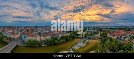 Dramatic sky at sunrise over Munich as panoramic aerial with a wonderful wide view over the bavarian capital city. View at the Frauenkirche in Stock Photo