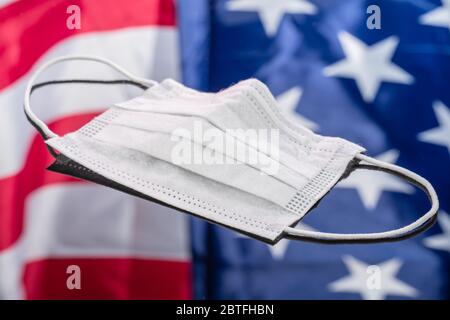 Disposable Dustproof Breathable Surgical Face Mouth Mask on mirror background with American flag reflected in it Stock Photo