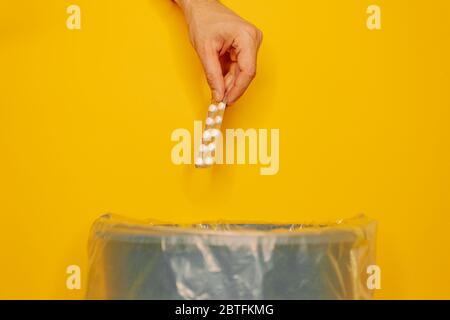 hand throwing pills away on orange background. Health concept Stock Photo