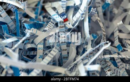 Shredded paper. The word paid in the centre of the image has been highlighted. Stock Photo