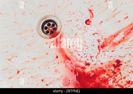 Fresh red blood splat on white porcelain with specks from the impact. Copy space area for horror themed concepts and ideas Stock Photo